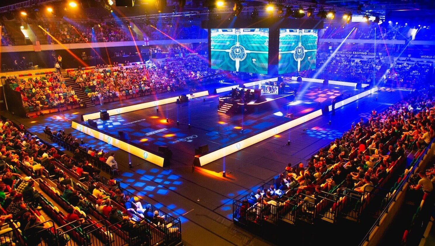 Esportstoernooi in volle gang in een grote arena, met gepassioneerde fans die kijken naar teams die concurreren op verlichte podiumschermen.